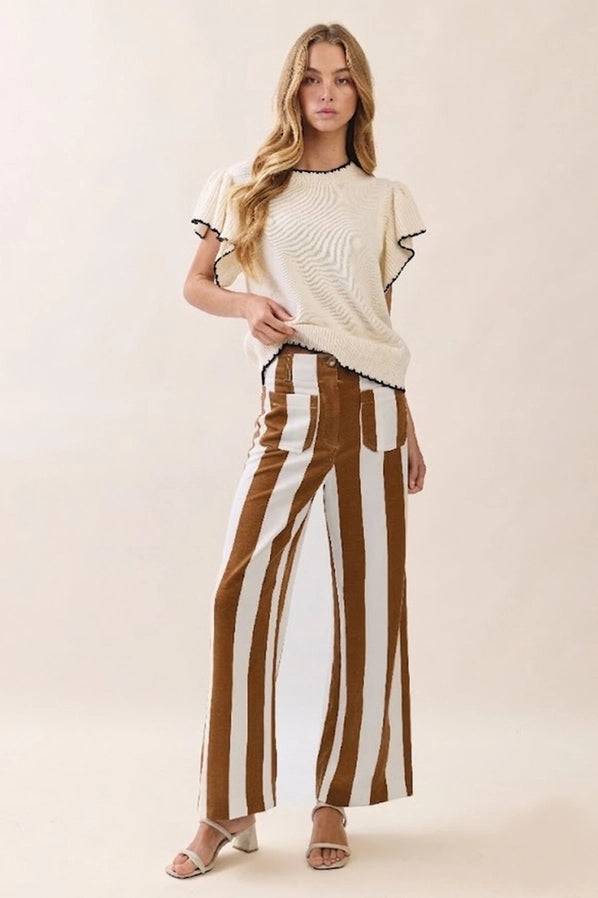 Woman modeling Oddi mocha brown and ivory vertical striped high-waisted wide-leg pants with front patch pockets, styled with a cream fitted top and tan sandals