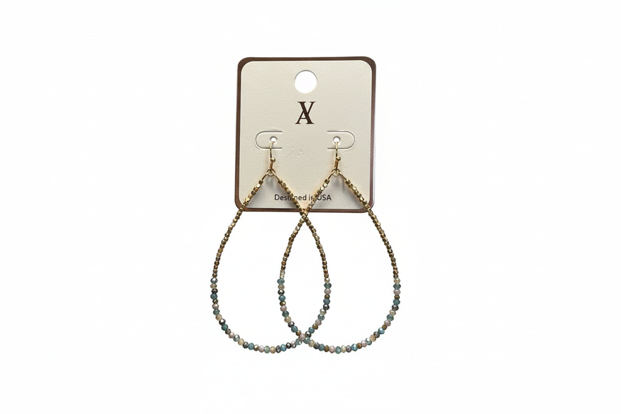 Hand holding a beaded necklace on a card with a blurred background
