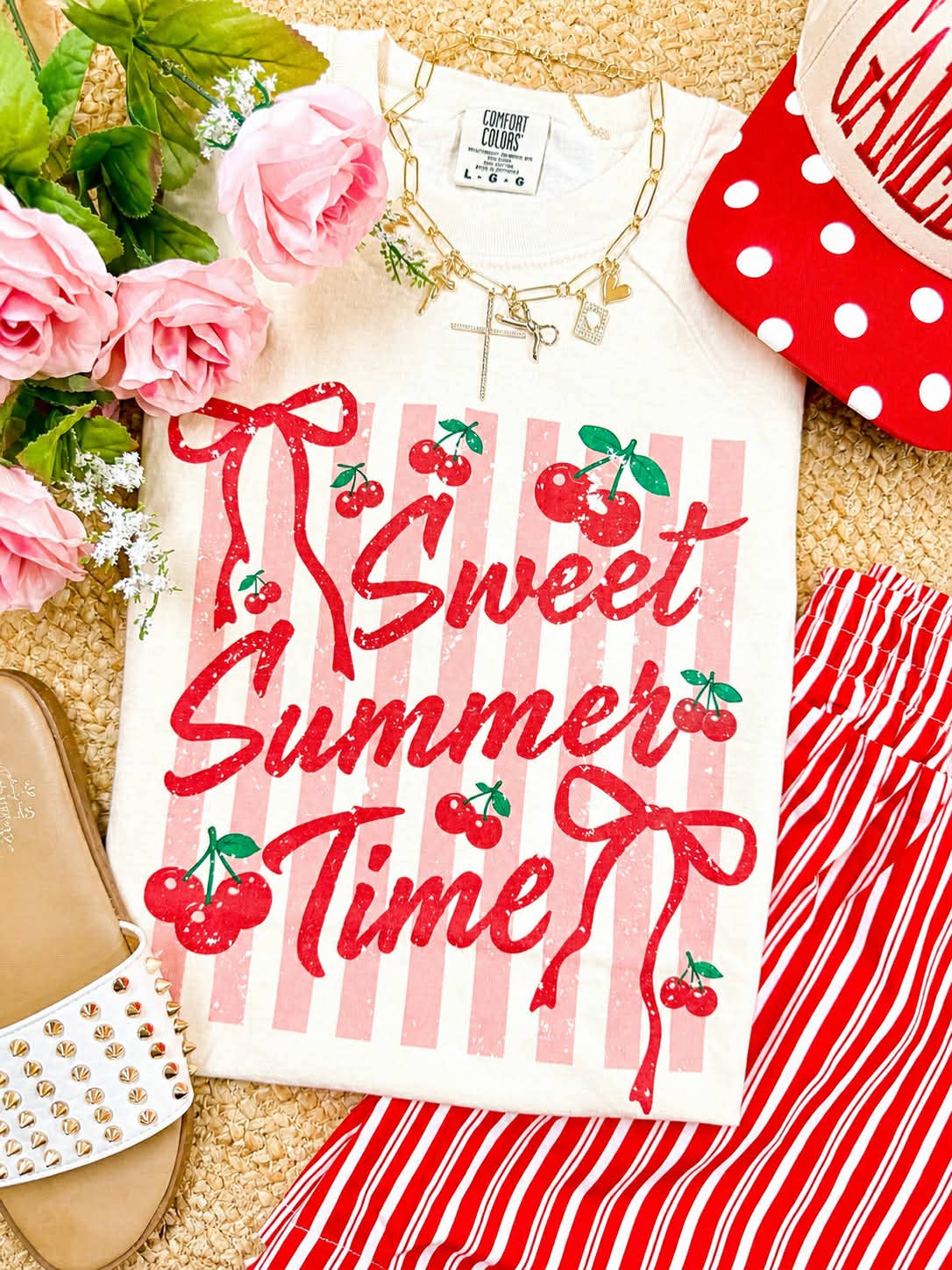 White t-shirt with 'Sweet Summer Time' design on a surface with flowers and accessories.