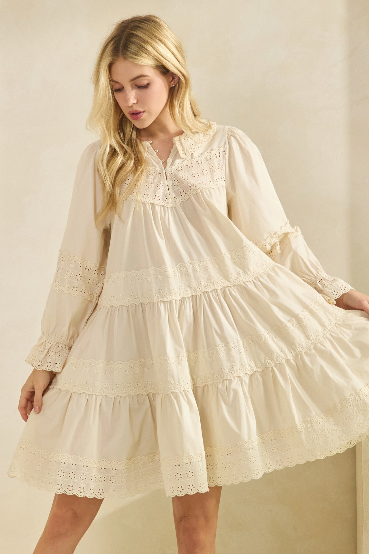 cream tiered babydoll dress with long sleeves and eyelet lace detail