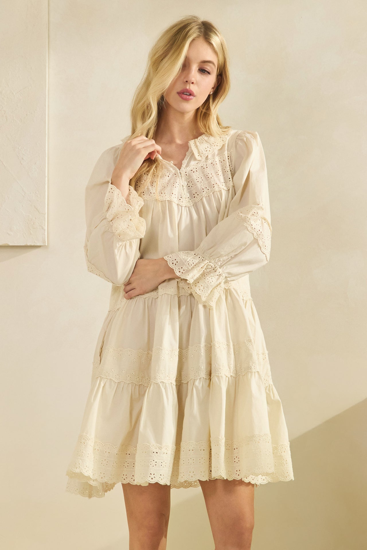 cream tiered dress with ruffle cuffs and scalloped lace hem detail