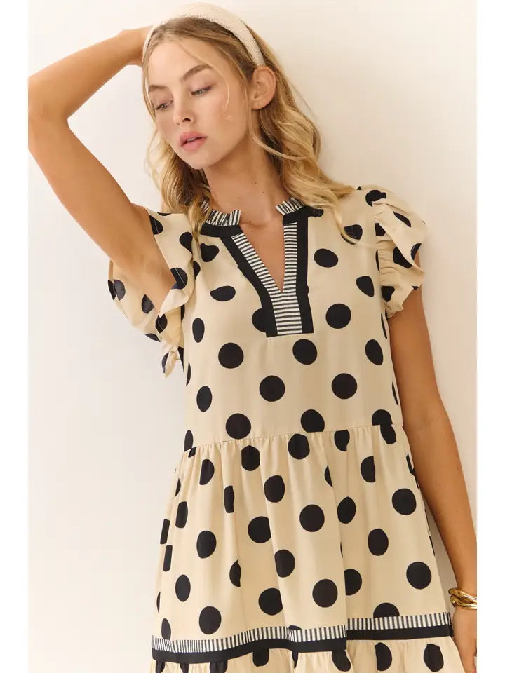 Woman wearing a polka dot dress with a plain background