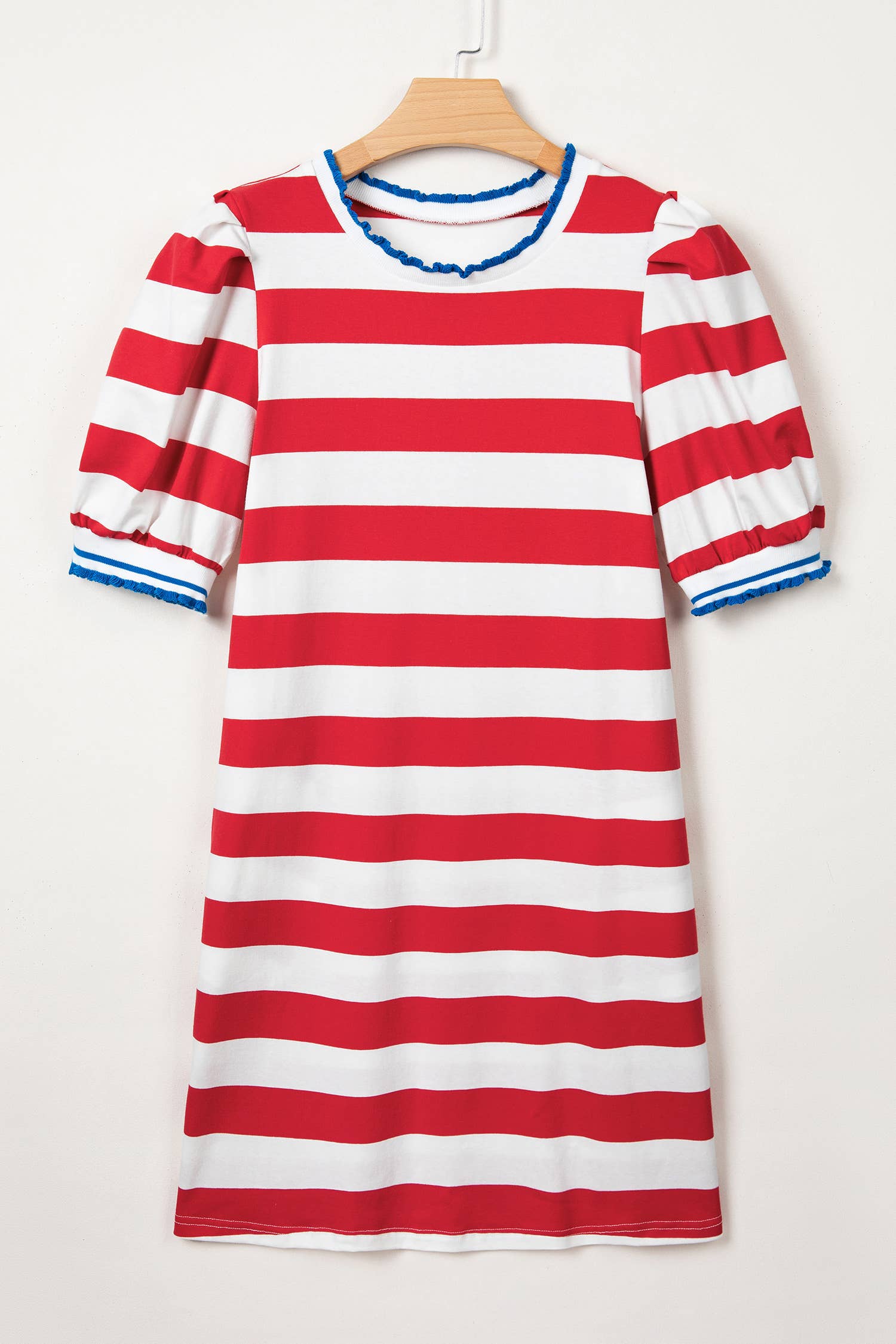 Red and white striped dress with blue trim on a wooden hanger against a white background
