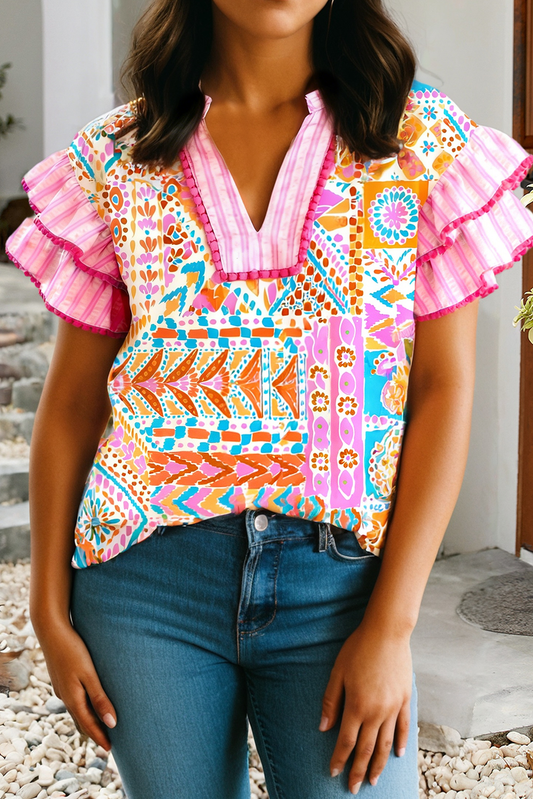Woman wearing a pink boho patchwork blouse with flutter sleeves and colorful mixed print styling