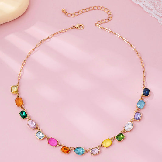 Necklace with colorful gemstones on a pink background