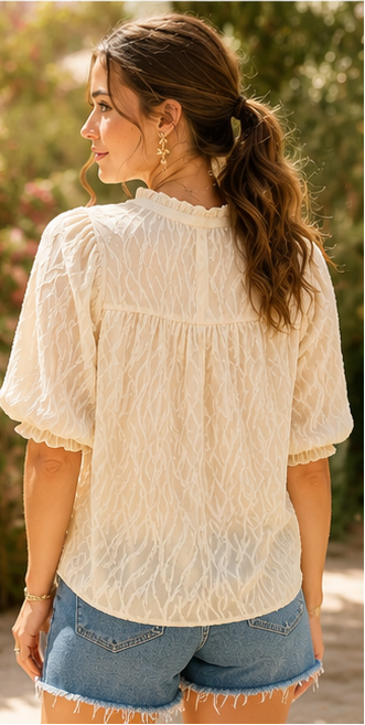 Woman wearing a white blouse and denim shorts in an outdoor setting