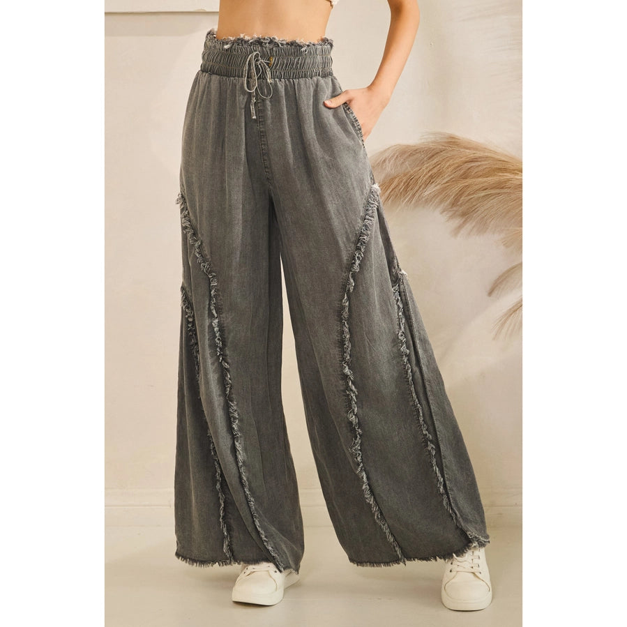 Gray wide-leg pants with frayed edges worn by a person on a neutral background