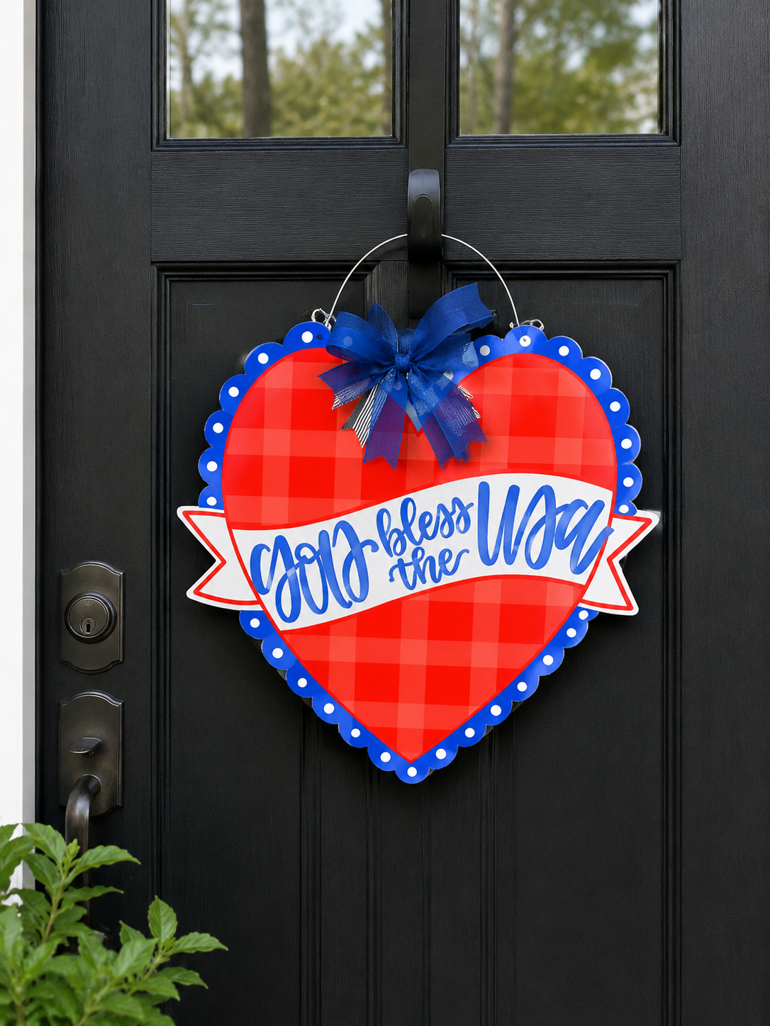Heart-shaped door decoration with 'God bless the USA' text on a black door.