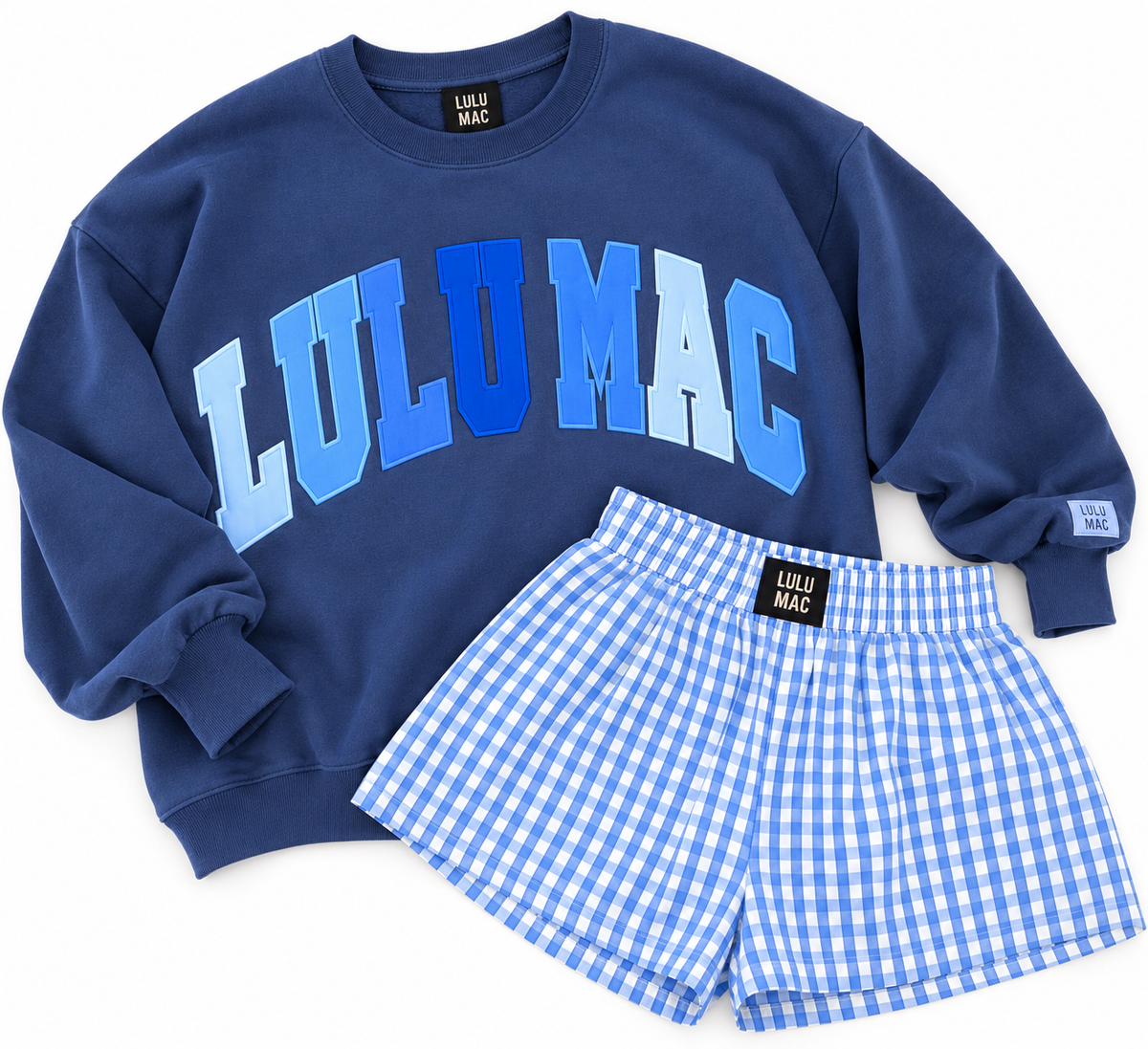 A two-piece set by LULU MAC, featuring a navy blue sweatshirt with a blue and light blue arched 'LULU MAC' graphic on the front, paired with light blue and white gingham check shorts.