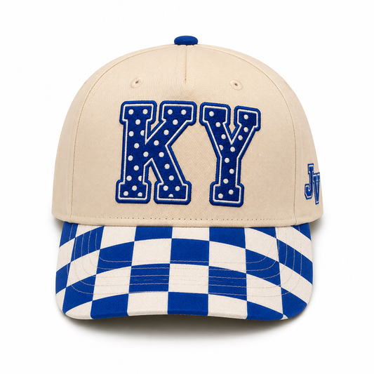 A beige baseball cap with blue and white checkered detailing on the brim and a blue dotted 'KY' letter patch on the front, shown against a plain white background.
