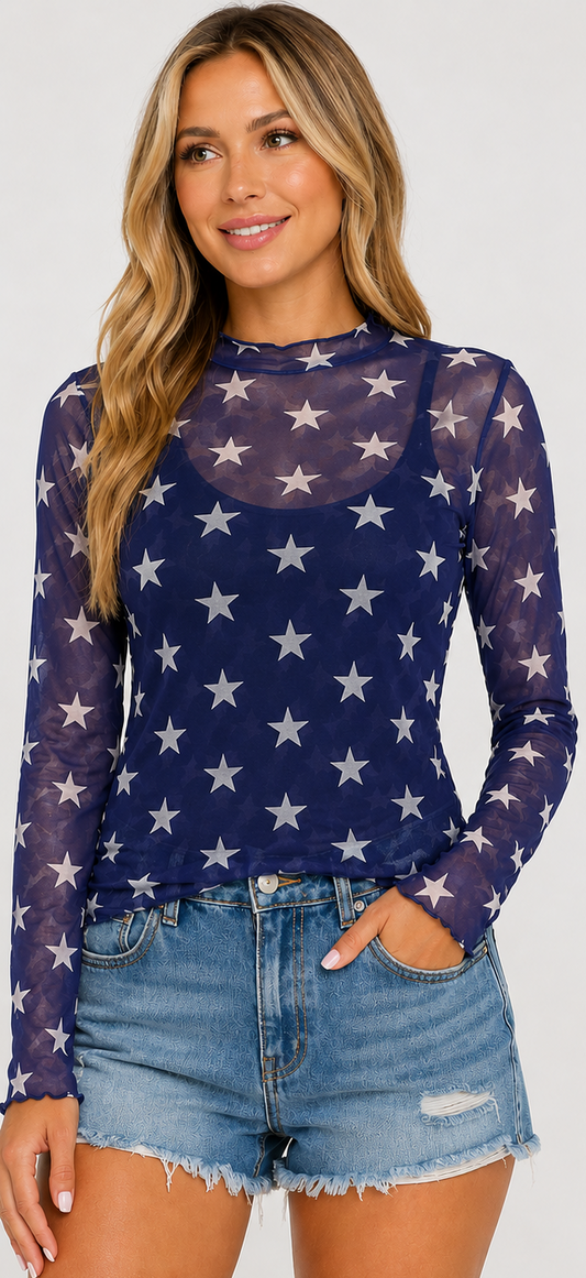Woman wearing a navy blue long-sleeve top with white star pattern and denim shorts.