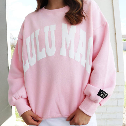 woman wearing light pink oversized sweatshirt with white graphic lettering