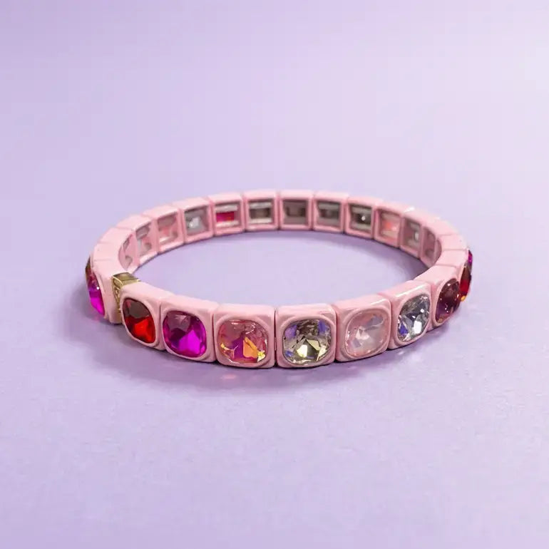 Pink bracelet with multicolored gemstones on a light purple background