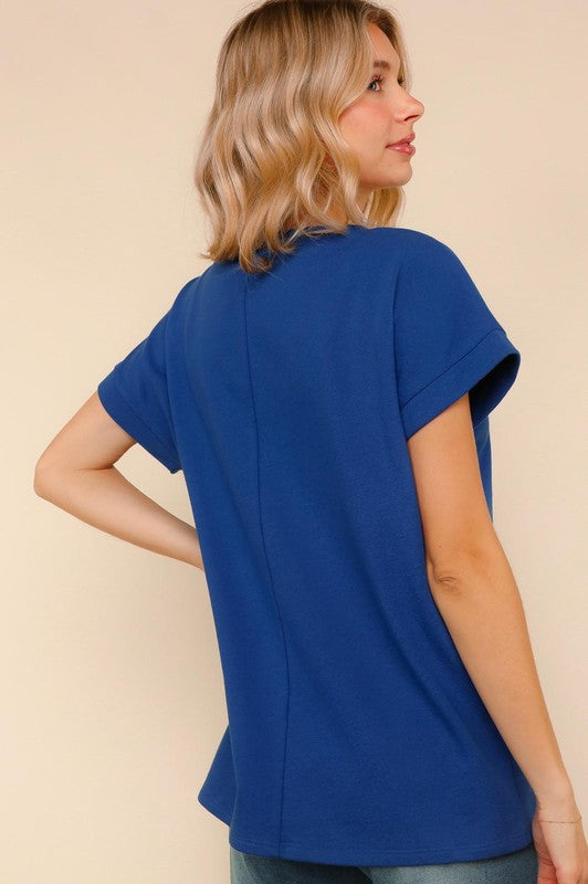 Woman wearing a blue top against a beige background