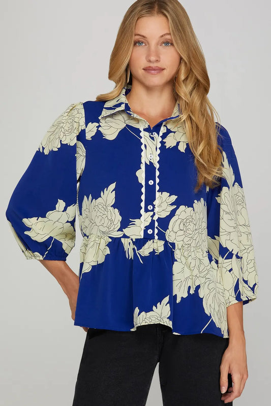 Woman wearing a blue floral blouse against a gray background