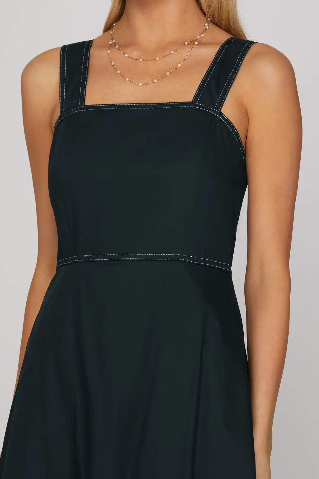 Dark green dress worn by a model on a plain background