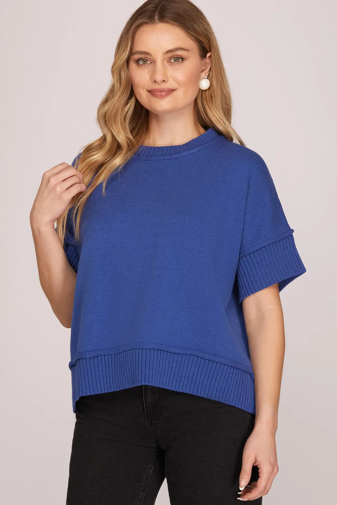 Woman wearing a blue sweater against a plain background