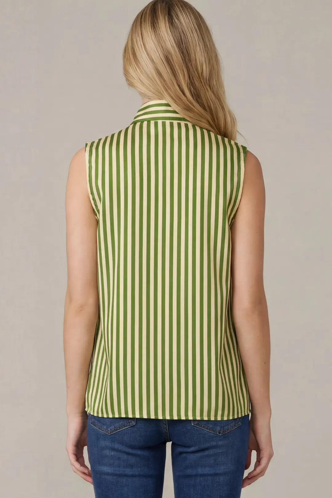 Person wearing a green and white striped sleeveless top against a neutral background
