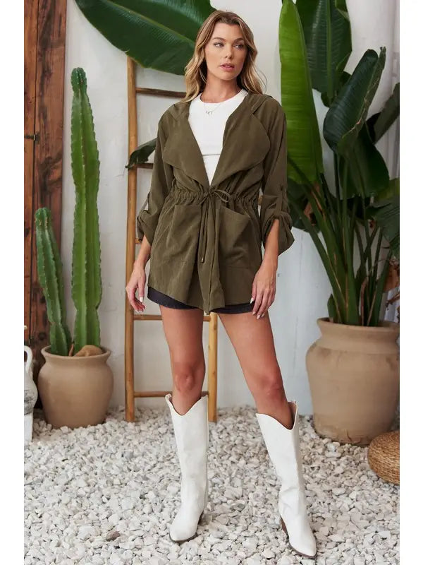 Olive lightweight hooded jacket, front three-quarter view, open over white top and black shorts