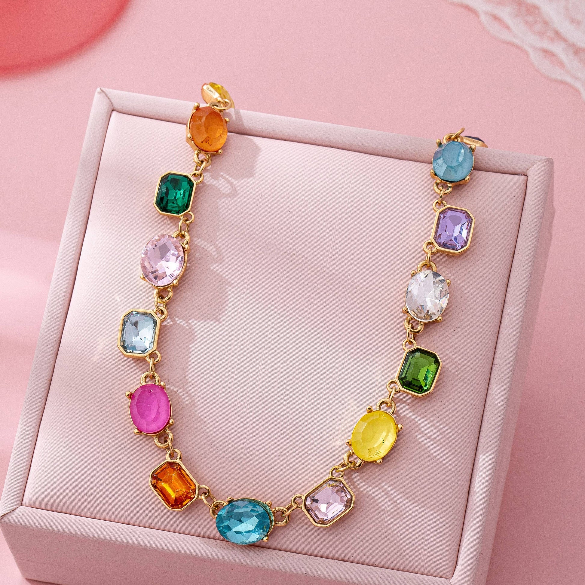Necklace with colorful gemstones on a pink box