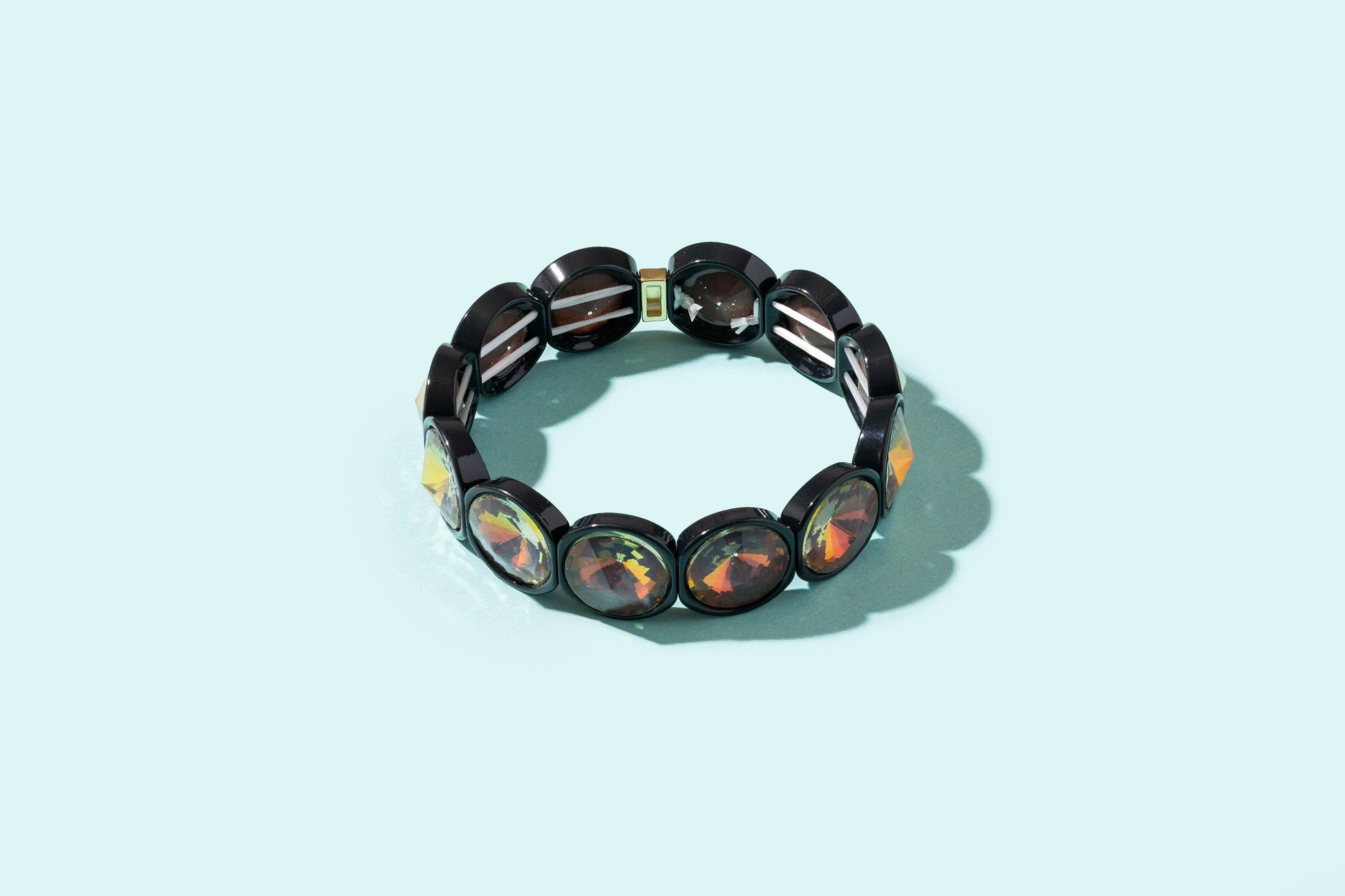 Black beaded bracelet with colorful stones on a light blue background