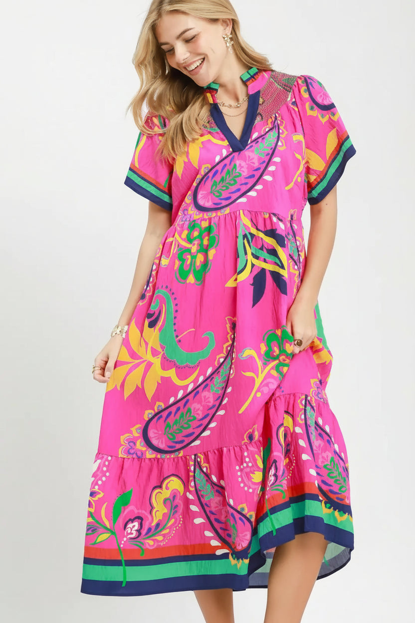 Woman wearing a colorful dress with a 'UMgee Exclusive' logo in the corner.