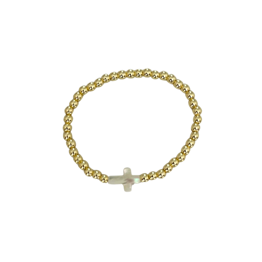 Gold beaded bracelet with a small white cross charm on a white background