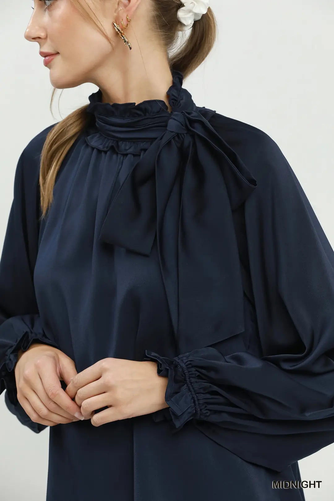 Umgee satin tie-neck ruffle blouse in midnight navy, close-up bow detail