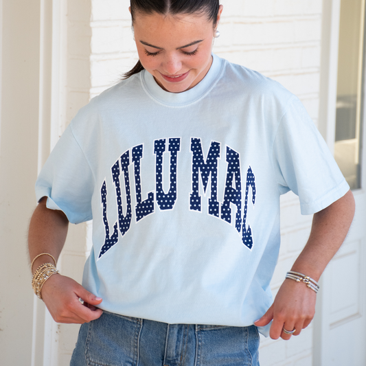Woman wearing Lulu Mac Chambray Polka Dot Comfort Colors® Graphic Tee featuring navy polka dot lettering on a soft chambray blue shirt.