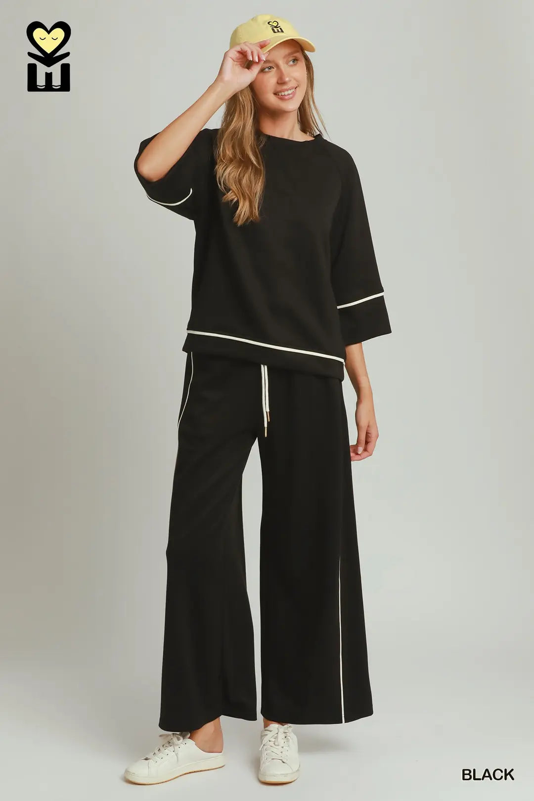 A model wearing a black umgee luxeknit top with white pipping