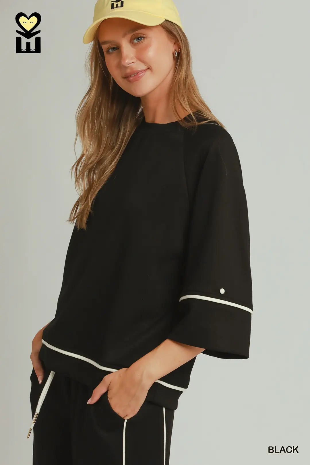 A model wearing a black umgee luxeknit top with white pipping