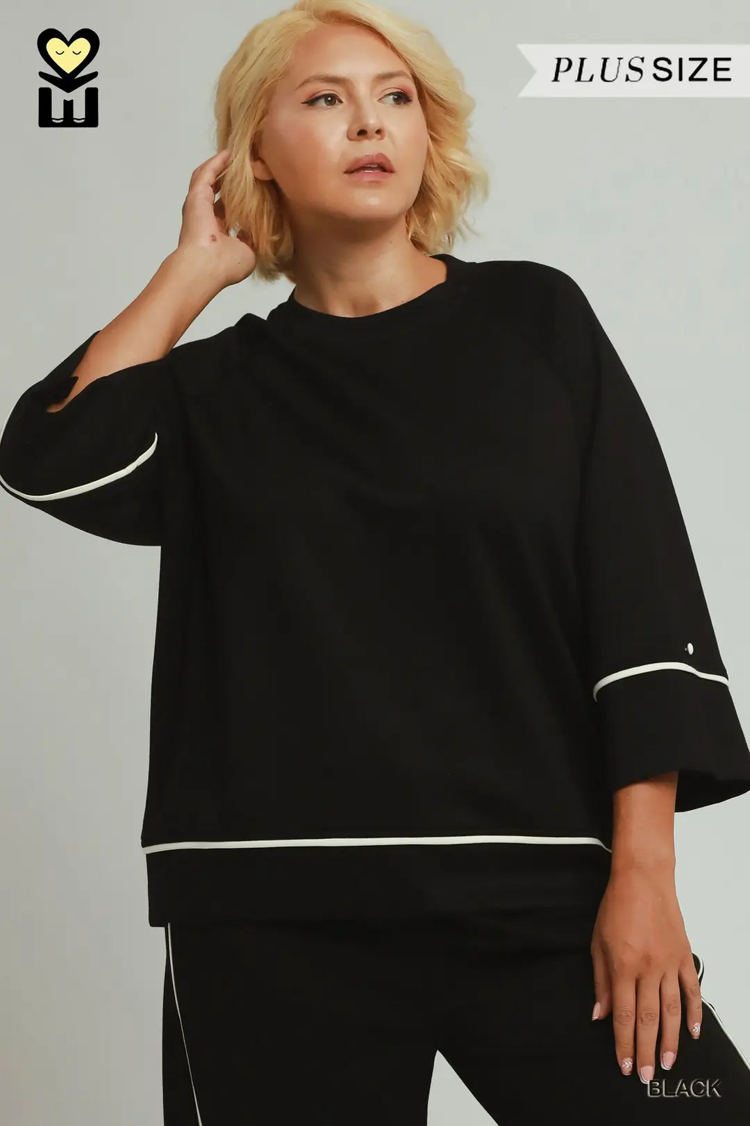 A model wearing a black umgee luxeknit top with white pipping
