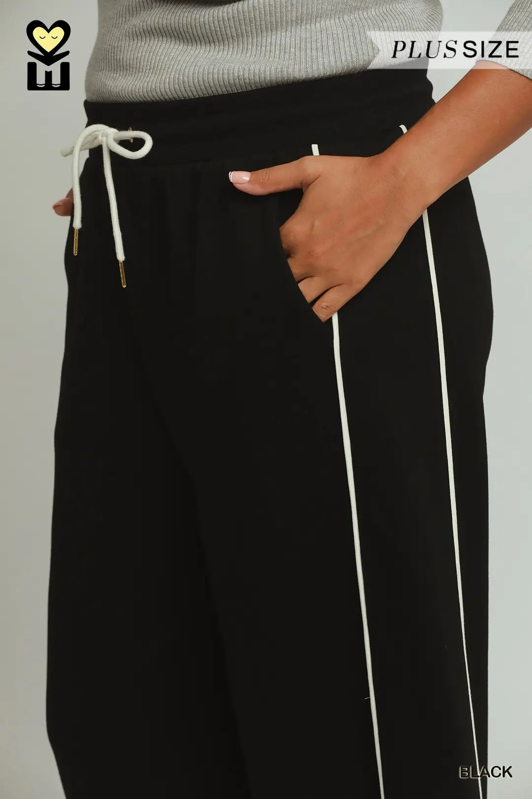 Black wide-leg sweatpants with white side stripes and a white drawstring waist, shown on a model wearing a gray ribbed top. The image includes 'PLUSSIZE' and 'BLACK' text overlays.