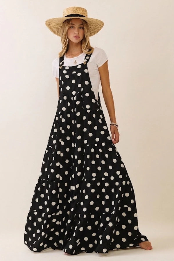 Woman wearing a black polka dot dress and straw hat on a white background