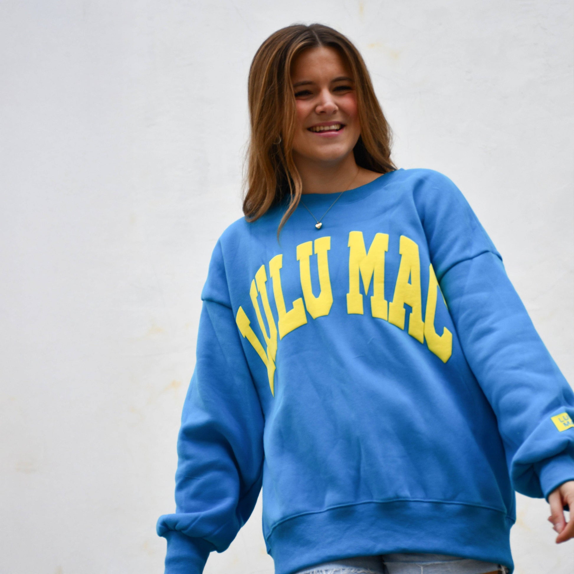 Woman wearing Lulu Mac Blue & Yellow Puff Sweatshirt featuring yellow raised puff lettering on a blue fleece sweatshirt.
