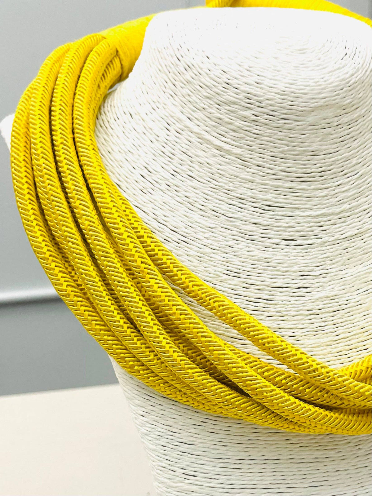White straw hat with a yellow band on a gray background