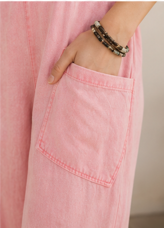 Woman wearing pink overalls in various poses outdoors.