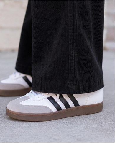 black umgee  corduroy pants on a model wearing a white and black striped sweater