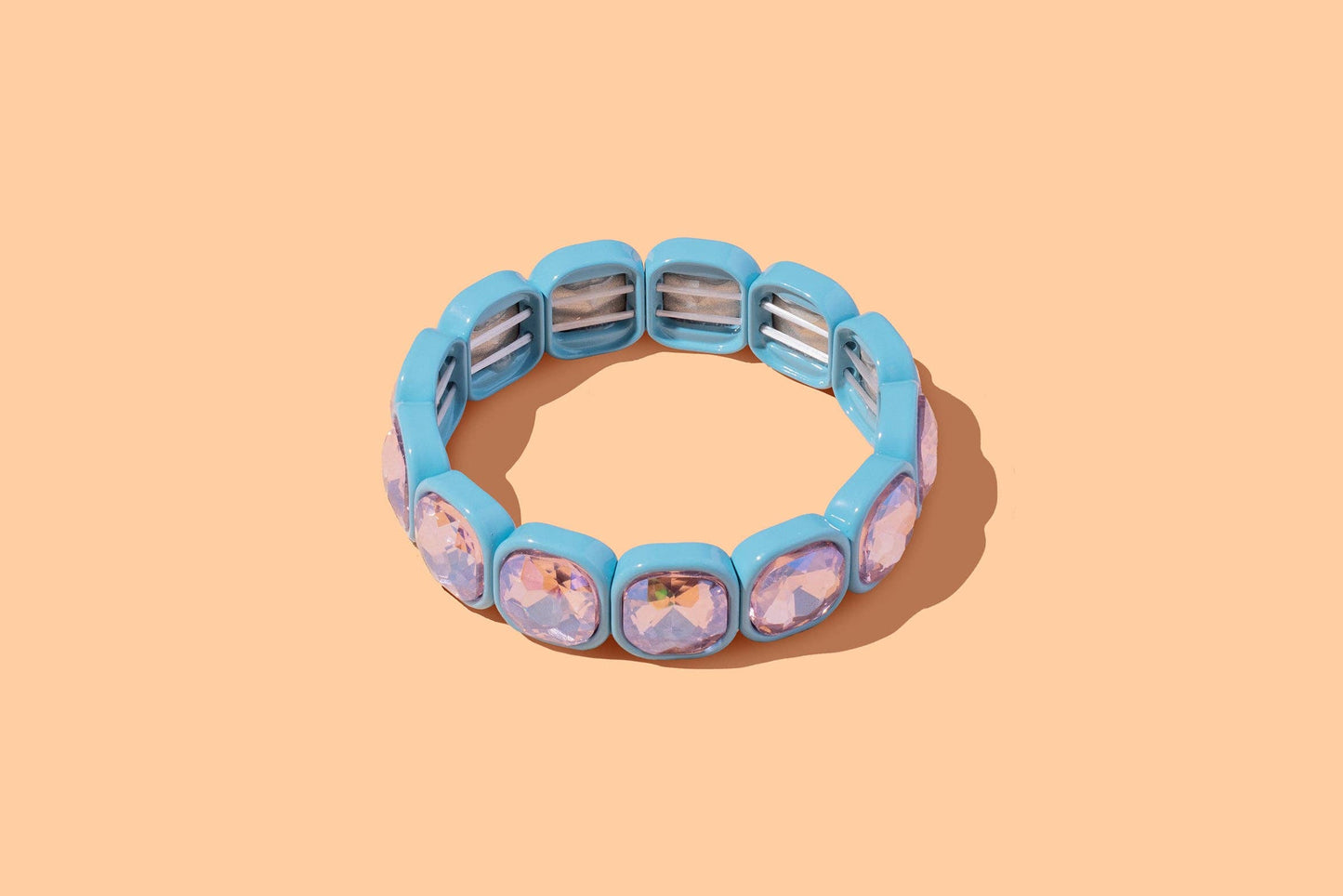 Blue bracelet with character-themed charms on a beige background