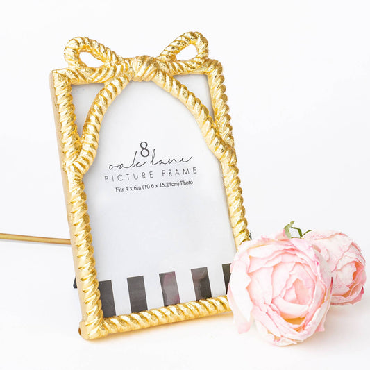 gold bow 4x6 picture frame with decorative ribbon design on tabletop