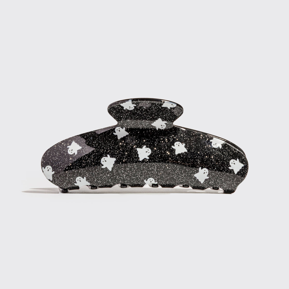 A black glittery hair claw clip decorated with small white cartoon ghosts, shown against a light gray background.