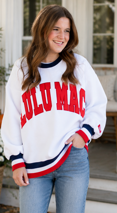 Woman wearing a white sweatshirt with 'LULO MAC' text, sitting on a couch, and standing outdoors.