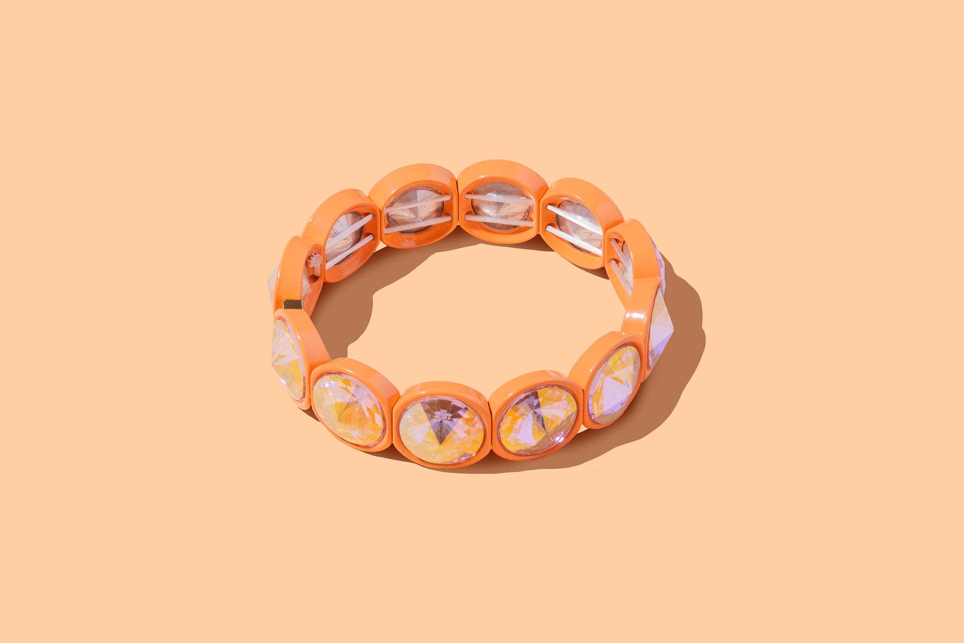 Orange bracelet with floral pattern on a peach background