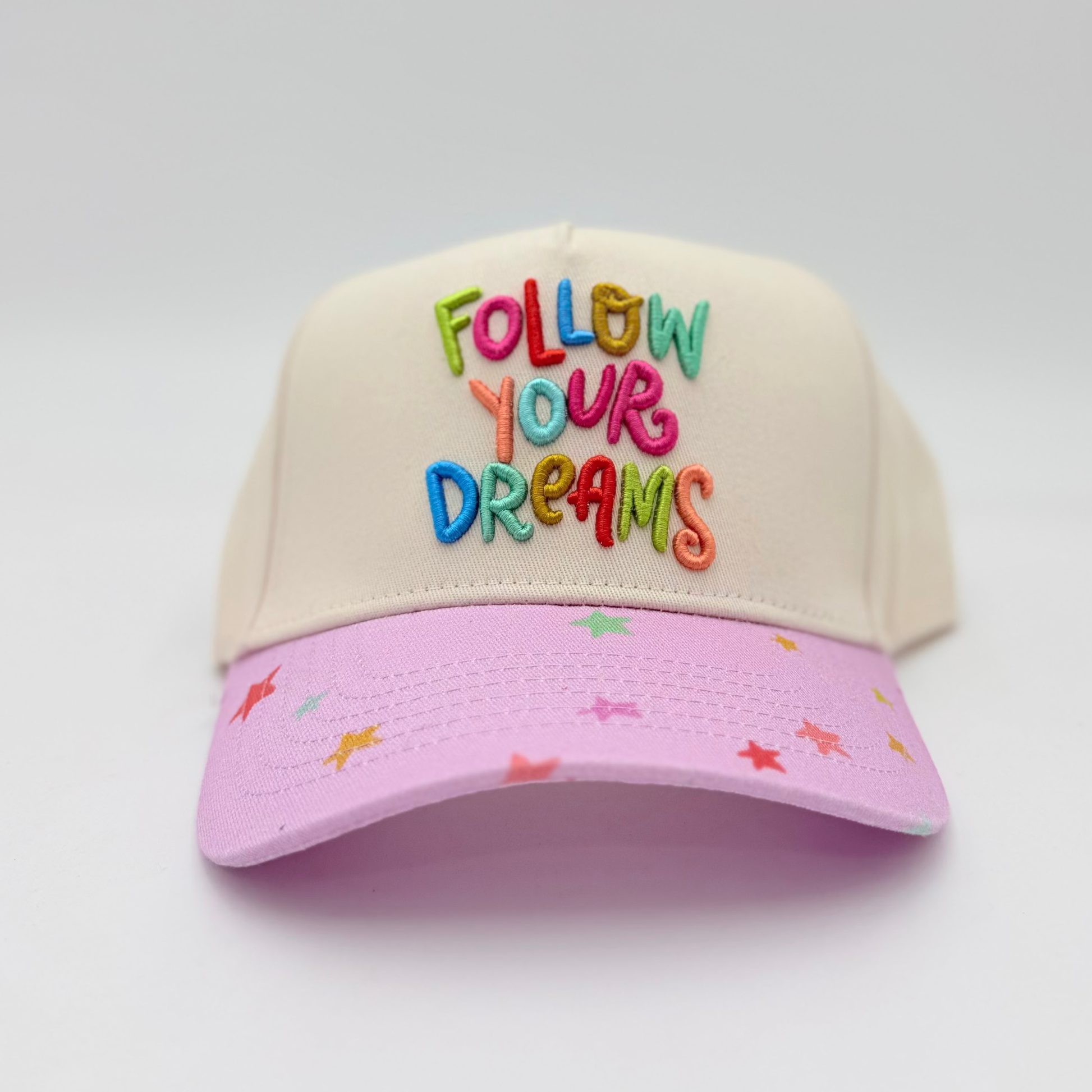 Two-tone cap with 'Follow Your Dreams' text on a white background