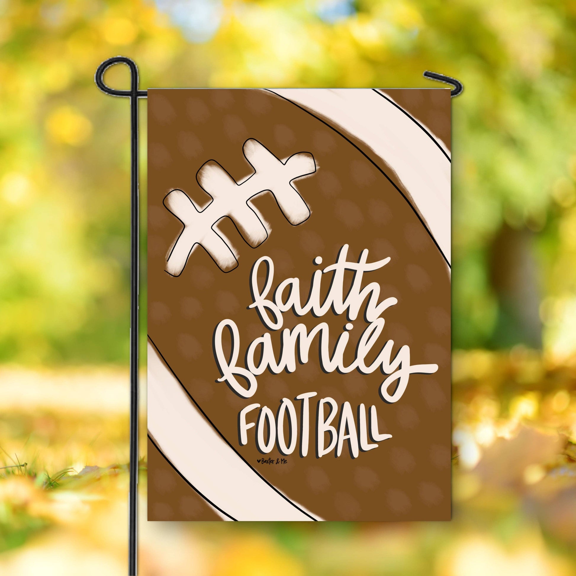 Decorative garden flag with 'Faith Family Football' text on a football design, outdoors.
