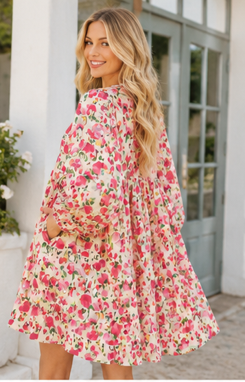 Woman wearing a floral dress standing outside a building.