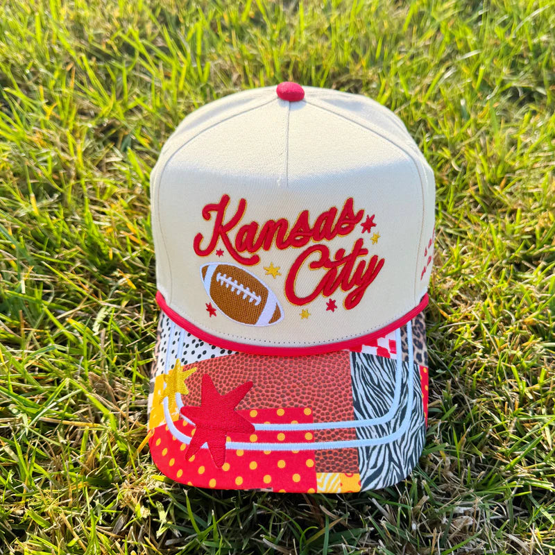 Cap with 'Kansas City' text and football graphic on grass