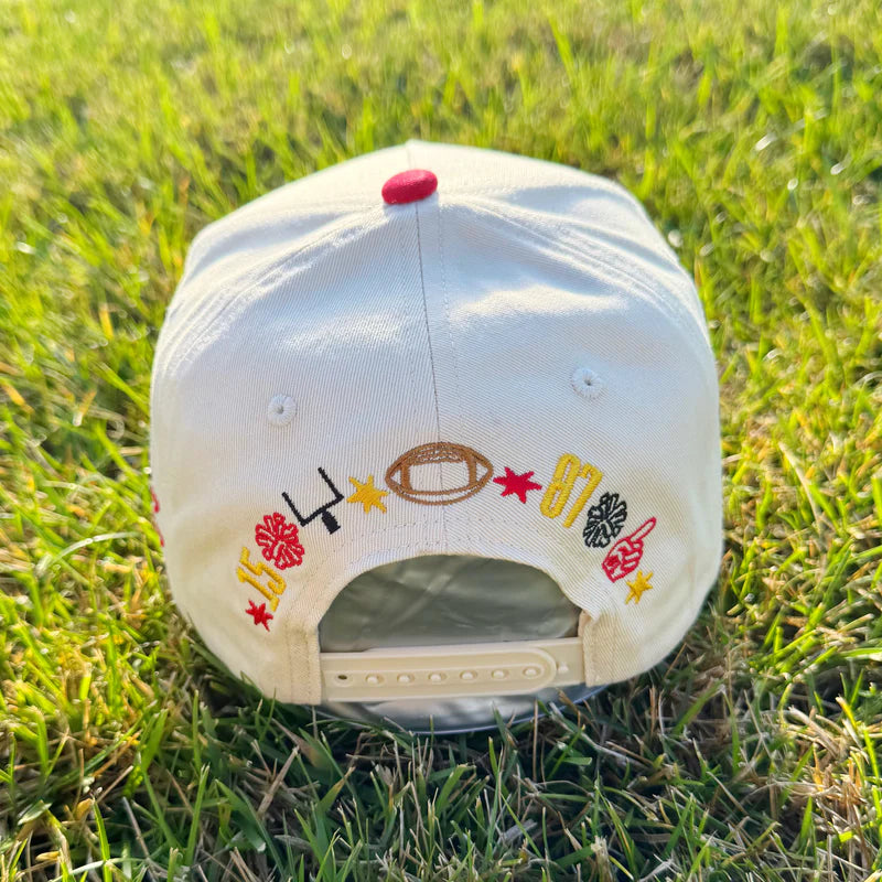 Baseball cap with sports-themed designs on grass
