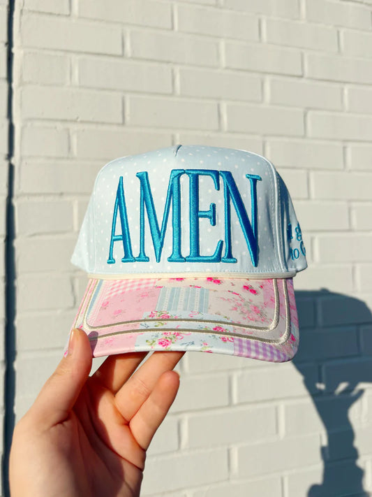 Women's floral AMEN trucker hat with embroidered lettering and adjustable mesh snapback.