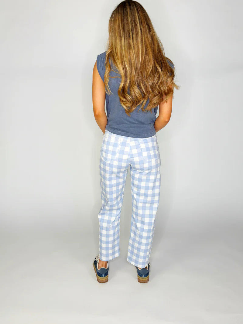 Woman wearing blue and white gingham barrel pants paired with a blue sleeveless top 
